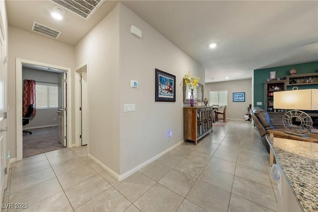 hallway with recessed lighting, visible vents, baseboards, and light tile patterned flooring