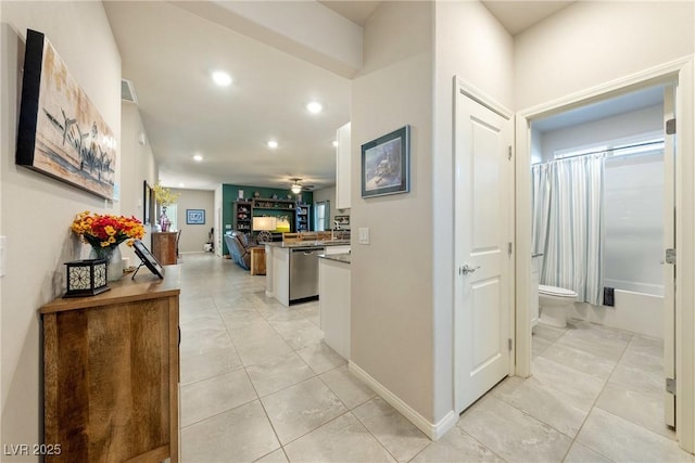 hallway with light tile patterned floors, recessed lighting, and baseboards