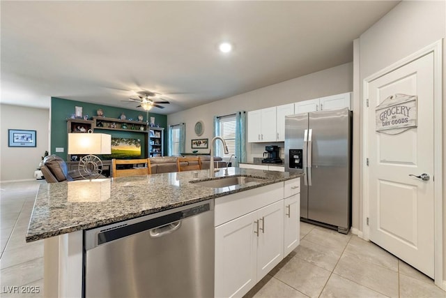 kitchen featuring open floor plan, a center island with sink, stainless steel appliances, and a sink