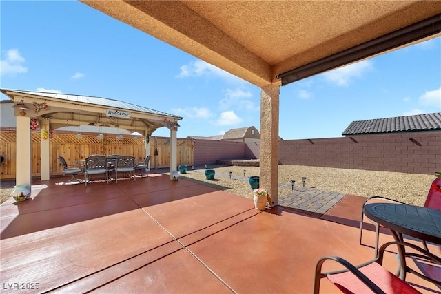 view of patio with a gazebo, outdoor dining area, and a fenced backyard