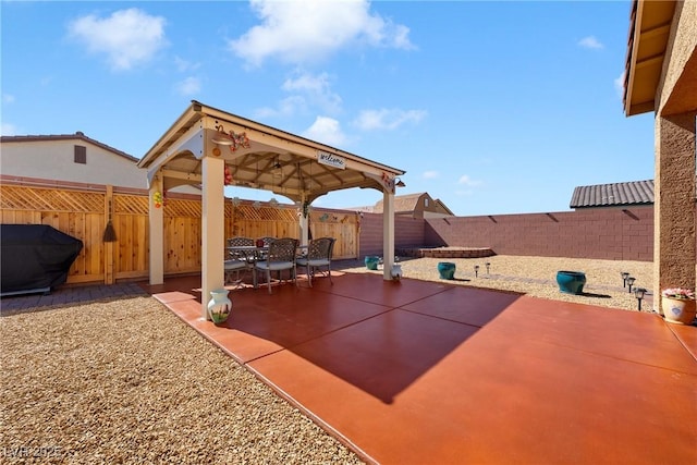 view of patio featuring a gazebo, area for grilling, and a fenced backyard