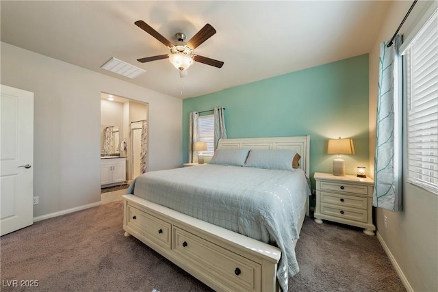 bedroom featuring dark colored carpet, connected bathroom, baseboards, and a ceiling fan