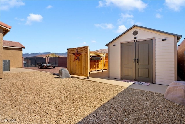 view of shed featuring a mountain view and fence