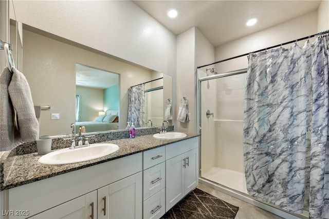 ensuite bathroom featuring double vanity, a shower stall, ensuite bathroom, and a sink