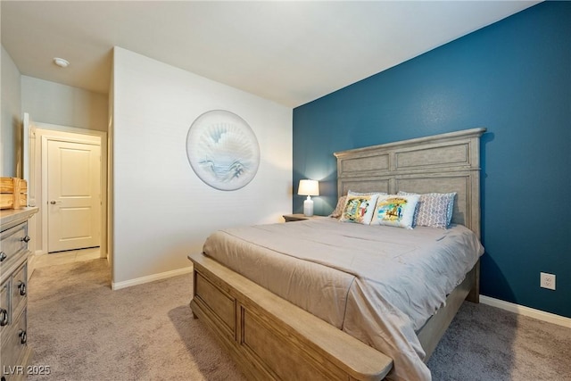 bedroom with light colored carpet and baseboards