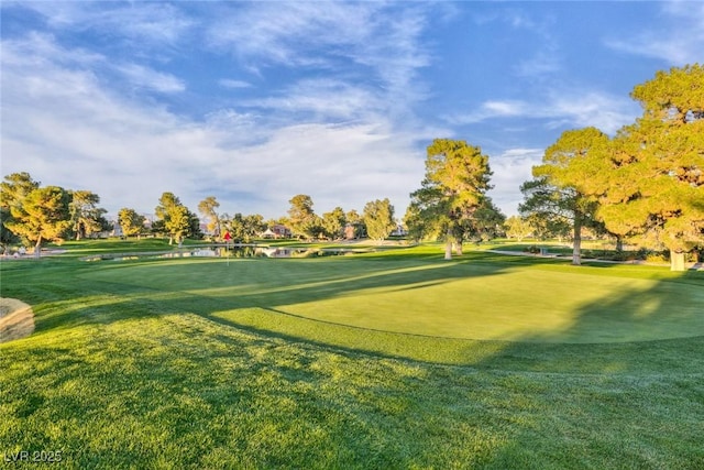 surrounding community featuring view of golf course and a yard