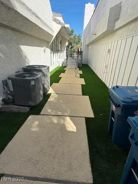 view of yard featuring a gate, fence, and central AC unit