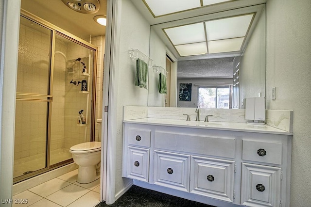 full bath with toilet, a stall shower, tile patterned floors, and vanity