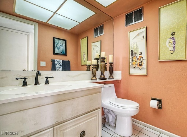 bathroom with toilet, vanity, and tile patterned floors