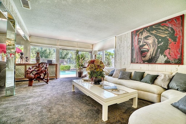 living area featuring carpet, visible vents, and a textured ceiling