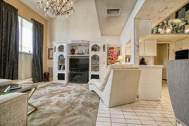 living area with an inviting chandelier, light tile patterned floors, and visible vents