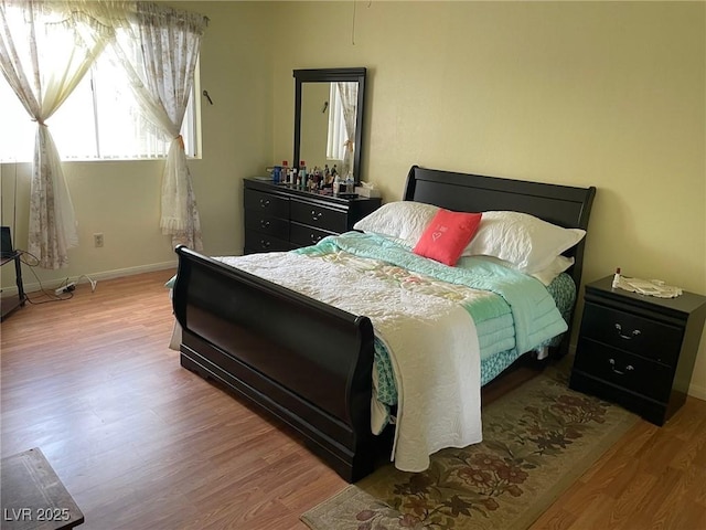 bedroom featuring baseboards and wood finished floors