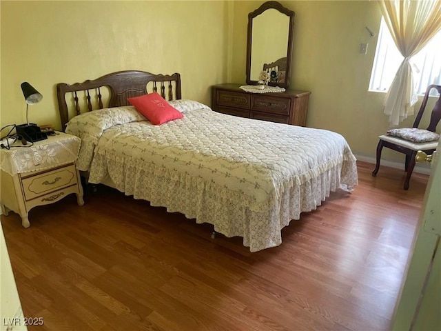 bedroom featuring dark wood-style floors and baseboards