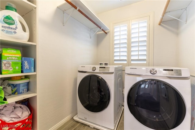 laundry room featuring wood finished floors, laundry area, baseboards, and separate washer and dryer