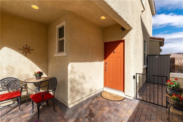 entrance to property with a patio area and stucco siding