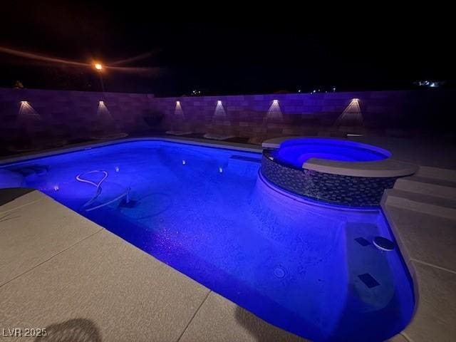 outdoor pool with a patio area, a fenced backyard, and an in ground hot tub