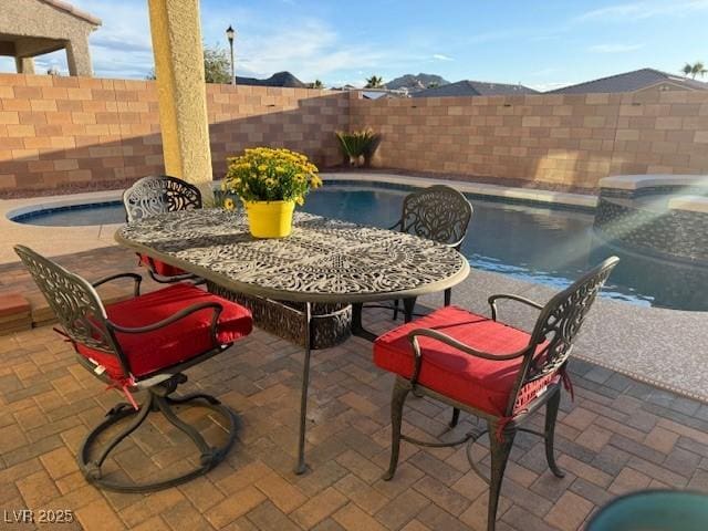 view of pool with outdoor dining space, a patio area, a fenced backyard, and a fenced in pool