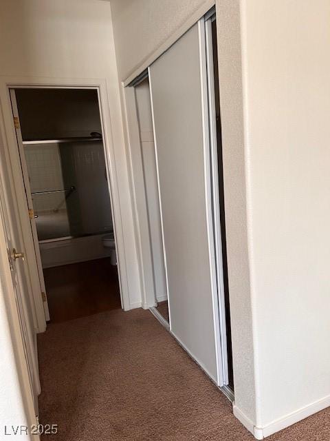 corridor with carpet flooring and baseboards