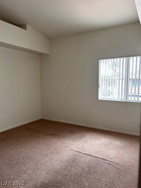 unfurnished room with carpet flooring and baseboards