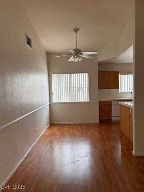 interior space featuring baseboards, ceiling fan, visible vents, and wood finished floors