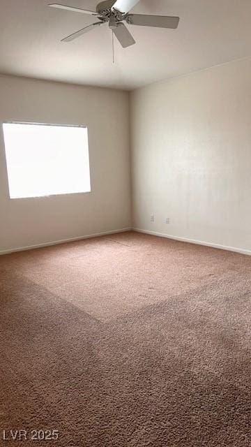 carpeted empty room featuring ceiling fan and baseboards