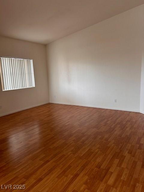 unfurnished room with baseboards and wood finished floors