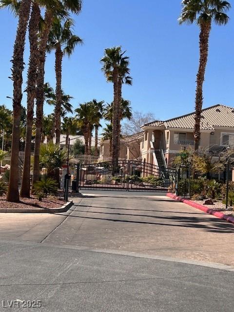 view of road with street lights, curbs, a gated entry, and a gate