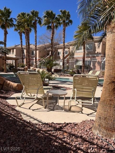 view of home's community featuring a patio area, a residential view, fence, and a pool