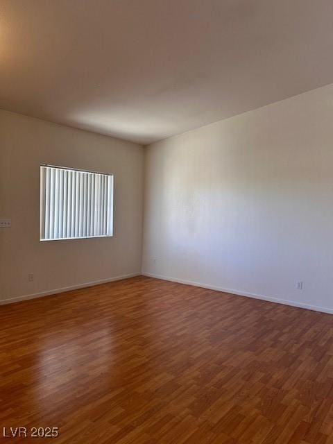 empty room with baseboards and wood finished floors