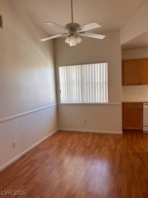 unfurnished living room with wood finished floors, a ceiling fan, and baseboards