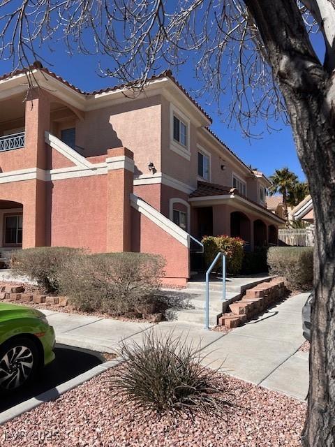 view of front of property featuring a tiled roof and stucco siding