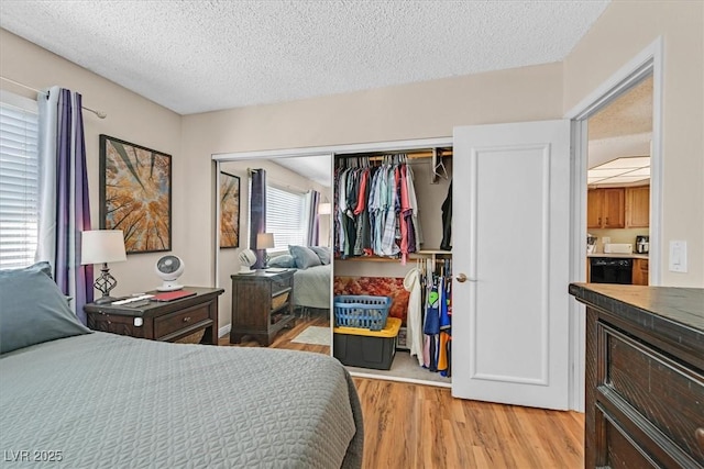 bedroom with a closet, light wood-style floors, and a textured ceiling