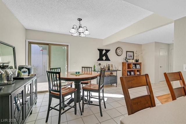 dining space with light tile patterned floors, a notable chandelier, and a textured ceiling