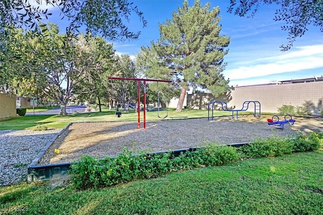 community jungle gym featuring a lawn and fence