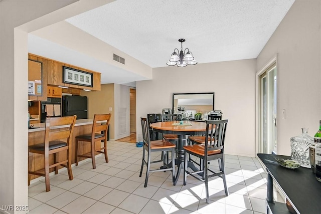 dining space featuring visible vents, a notable chandelier, light tile patterned flooring, and a textured ceiling