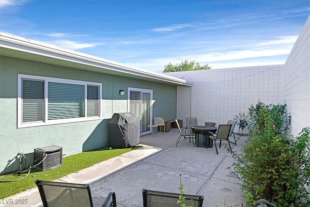 view of patio with outdoor dining area and a grill