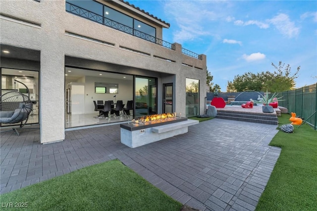 view of patio / terrace with a fenced backyard, a fire pit, and a balcony