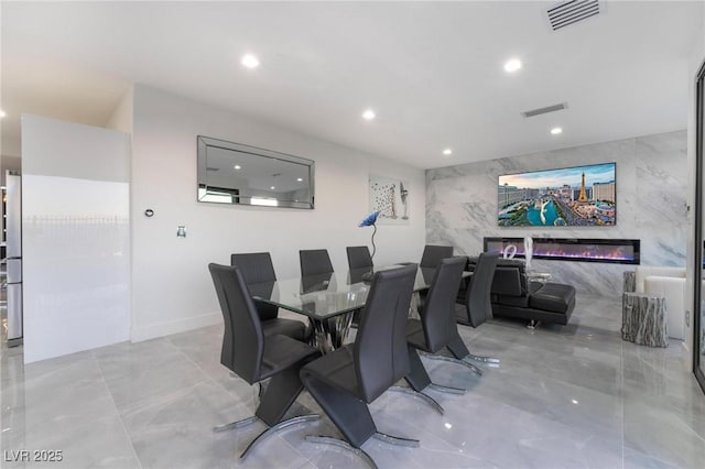 dining area featuring a premium fireplace, visible vents, and recessed lighting