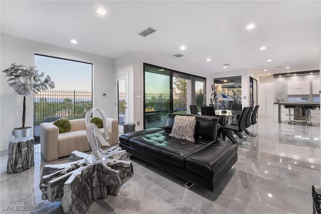 living room with marble finish floor, a wealth of natural light, visible vents, and recessed lighting