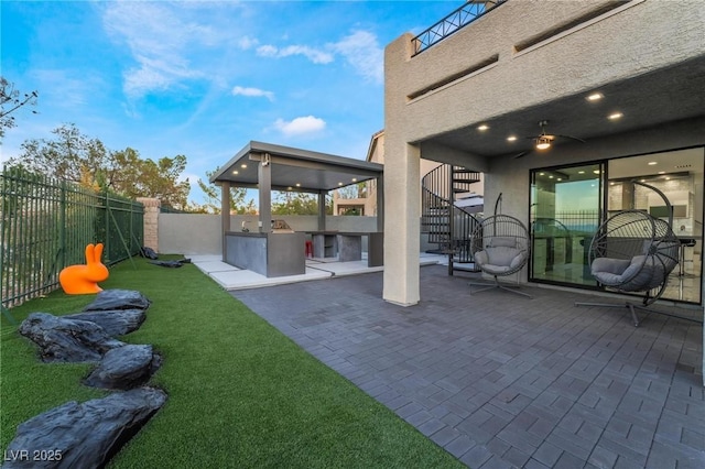 view of yard featuring a patio, stairway, an outdoor kitchen, and a fenced backyard