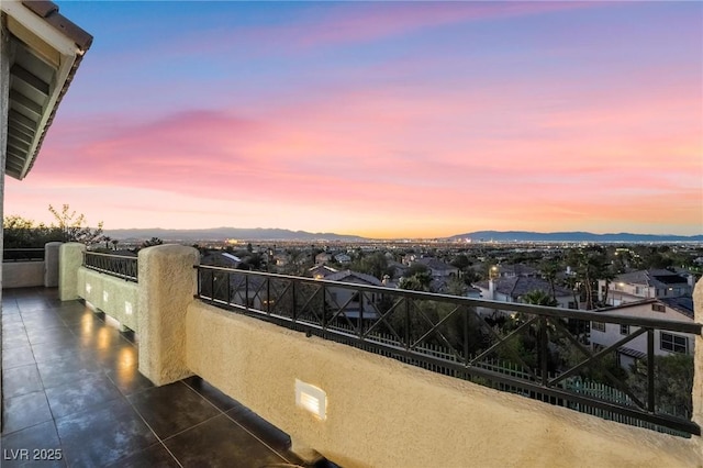 balcony at dusk featuring a mountain view