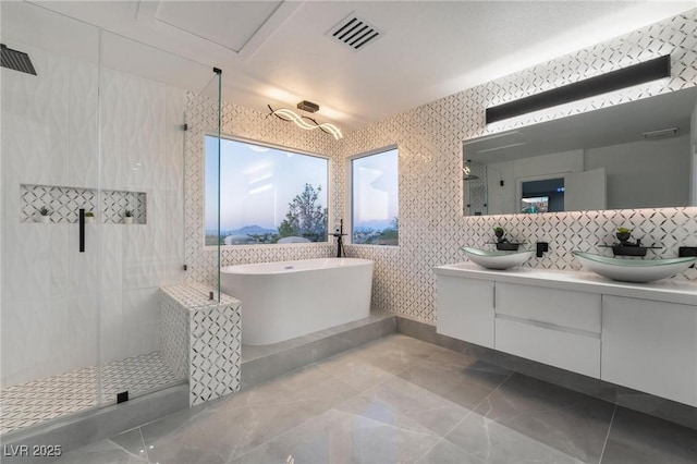 full bath with a stall shower, visible vents, a sink, and a soaking tub