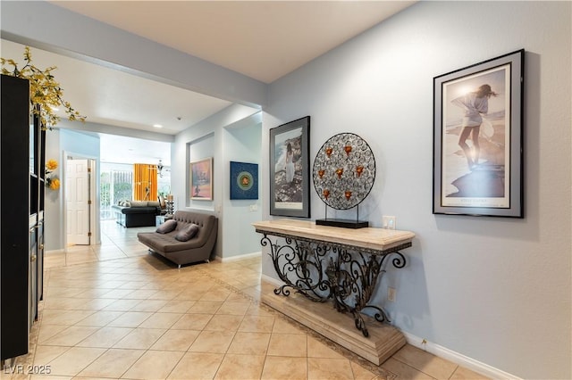 hall featuring light tile patterned floors and baseboards