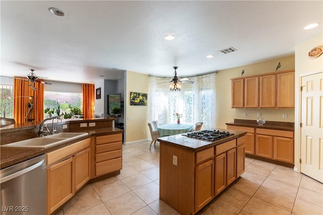 kitchen featuring a sink, visible vents, gas stovetop, stainless steel dishwasher, and dark countertops