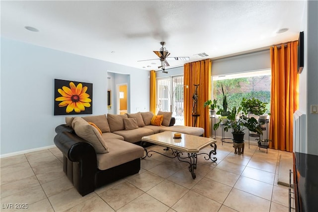 living room featuring ceiling fan, light tile patterned flooring, visible vents, and baseboards