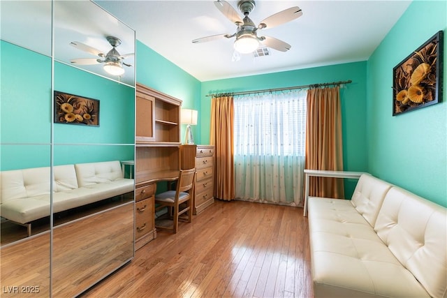 home office featuring visible vents, ceiling fan, and light wood finished floors