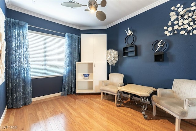 living area with baseboards, crown molding, a ceiling fan, and wood finished floors