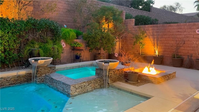 view of pool featuring an in ground hot tub, an outdoor fire pit, and a fenced backyard