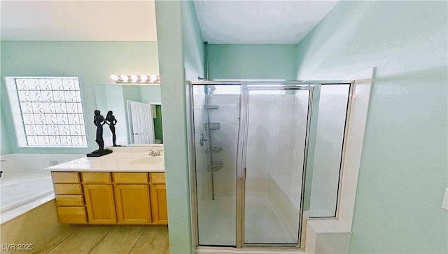 bathroom featuring a garden tub, a shower stall, and vanity