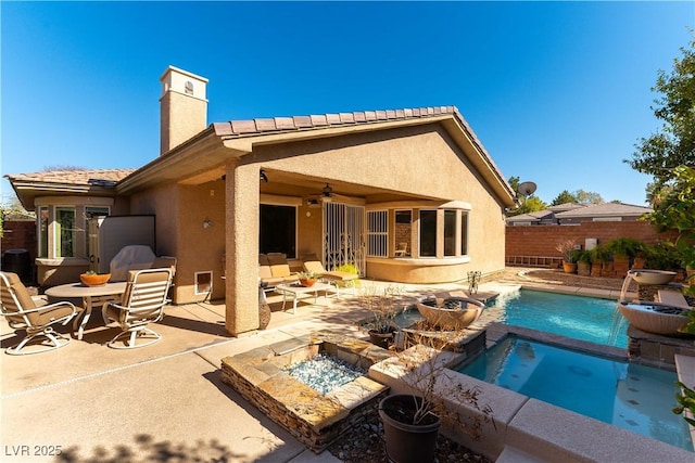 rear view of house with a ceiling fan, a fenced in pool, a patio, fence, and stucco siding